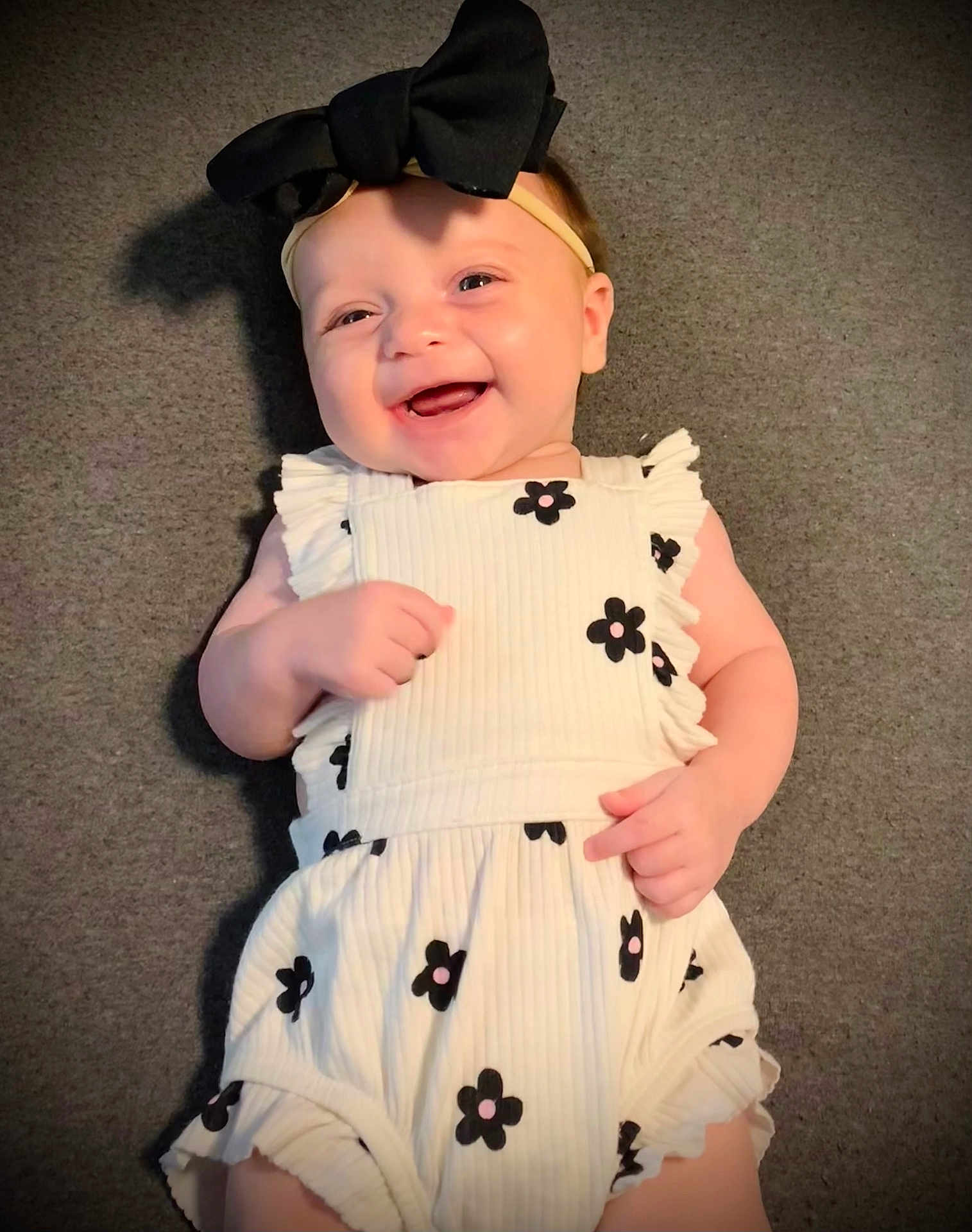 Zoie joined the competition — help win amazing prizes! baby, smiling, headband, bow, dress, flower_print, infant, happy, lying_down, carpet, cute, child, portrait, one_person, indoors, fashion, young_child, skin, head, hand