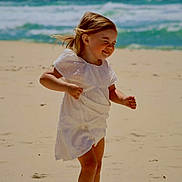 Diamond joined the competition — help win amazing prizes! child, beach, sand, ocean, waves, white_dress, purple_sandals, jumping, smiling, sunny, wind, hair, playful, happy, outdoor, nature, portrait, summer, vacation, fun