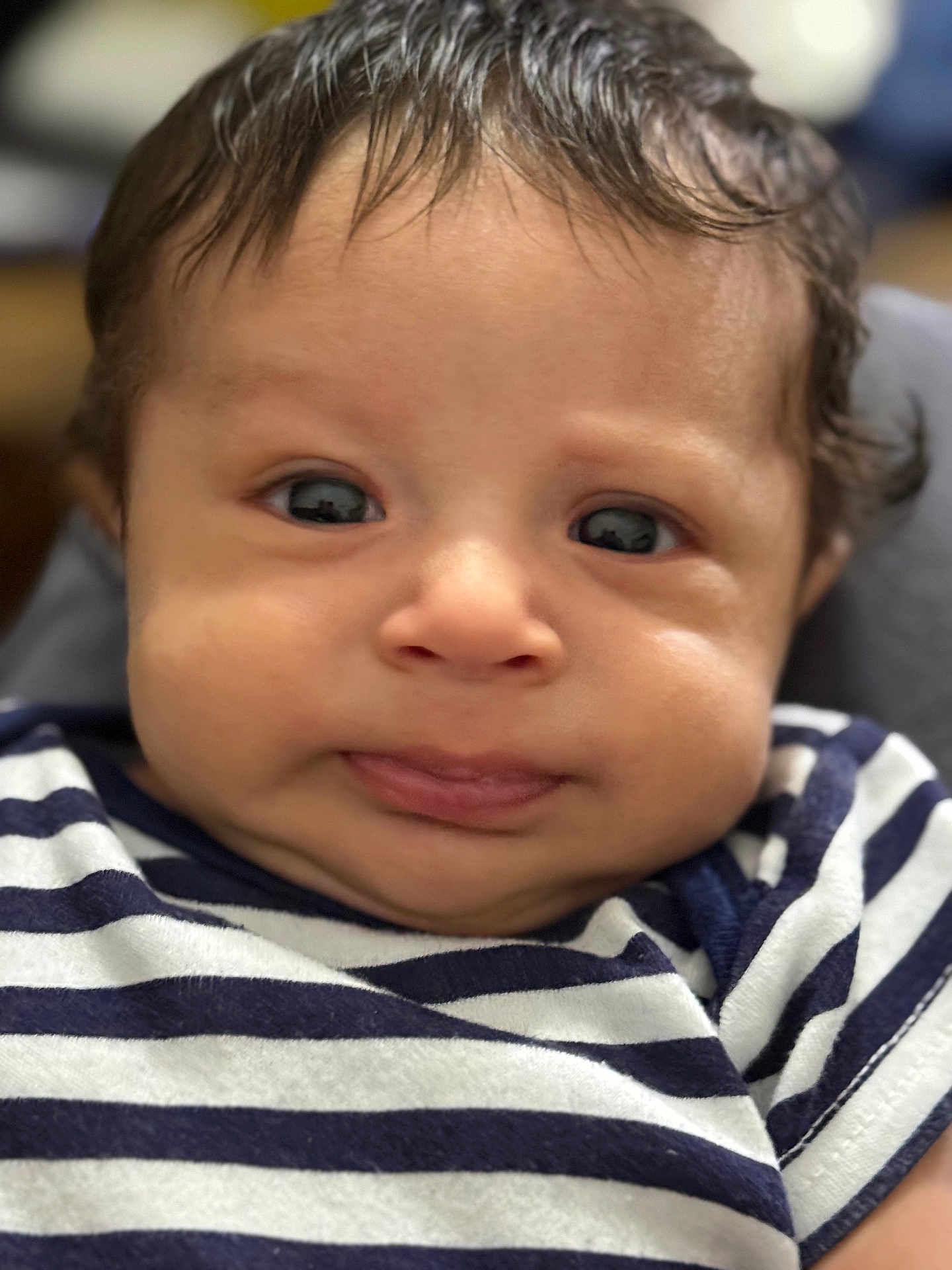 Liam joined the competition — help win amazing prizes! baby, child, face, portrait, close_up, striped_shirt, curious_expression, tongue_out, chubby_cheeks, person, infant, cute, young_child, soft_lighting, indoors, head, eyes, hair, skin, clothing