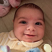 Ambre a rejoint le concours — aidez-le/la à gagner de superbes lots ! adorable, baby, blanket, cheeks, close_up, cozy, eyes, face, indoor, infant, newborn, nursery, onesie, pacifier, pacifier_clip, plush_toy, portrait, smile, soft_toy, stuffed_animal