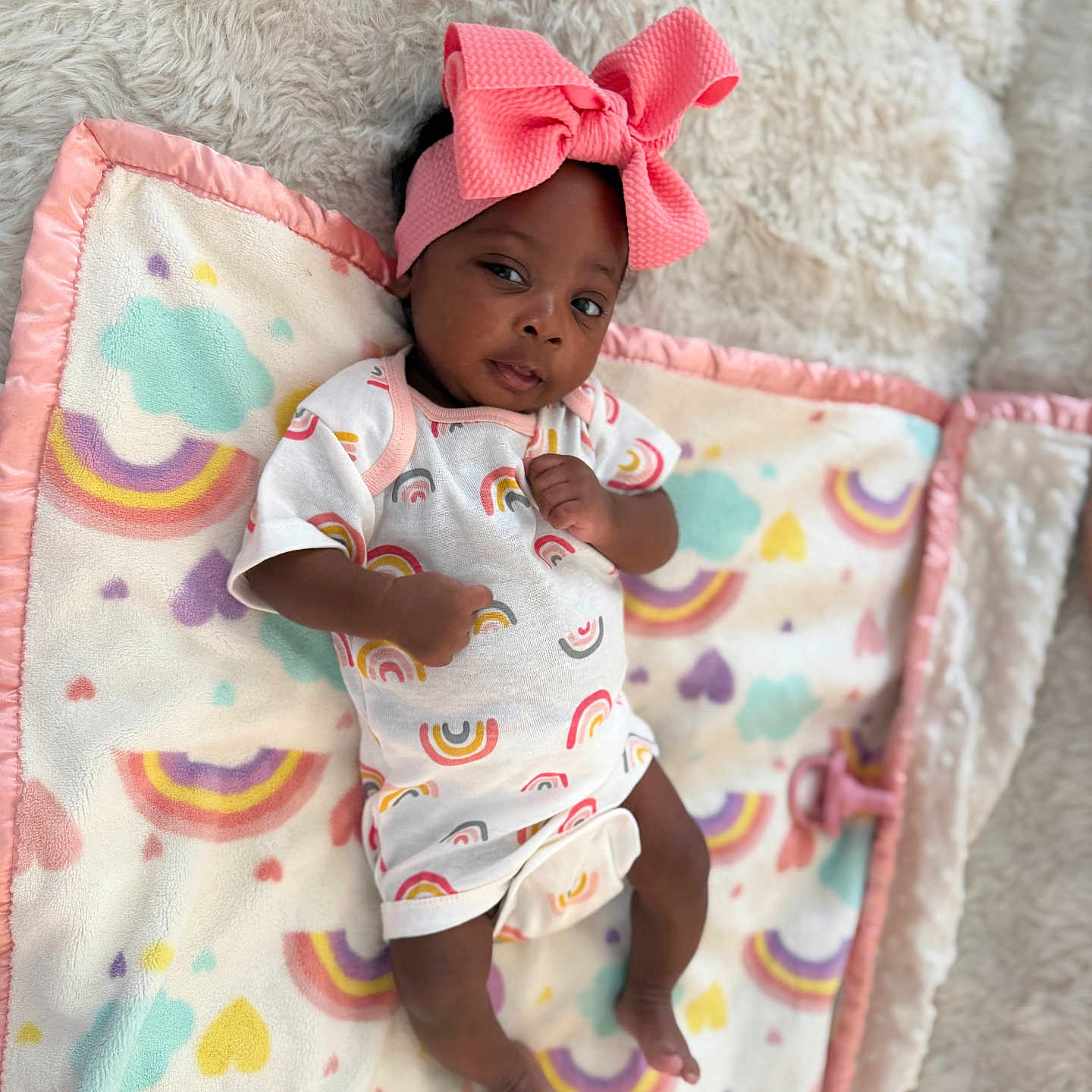 Fawlyn is registered to the contest to win money with this photo: baby, infant, headband, pink_bow, rainbow_pattern, blanket, soft_texture, lying_down, cute, clothing, colorful, toddler, portrait, child, newborn, indoors, happy, cozy, person, baby_girl