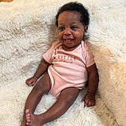 Fawlyn is registered to the contest to win money with this photo: baby, infant, smiling, pink_onesie, fluffy_blanket, happy, tongue_out, cute, child, portrait, indoor, cozy, soft_texture, sitting, young, person, skin, hair, furniture, relaxed