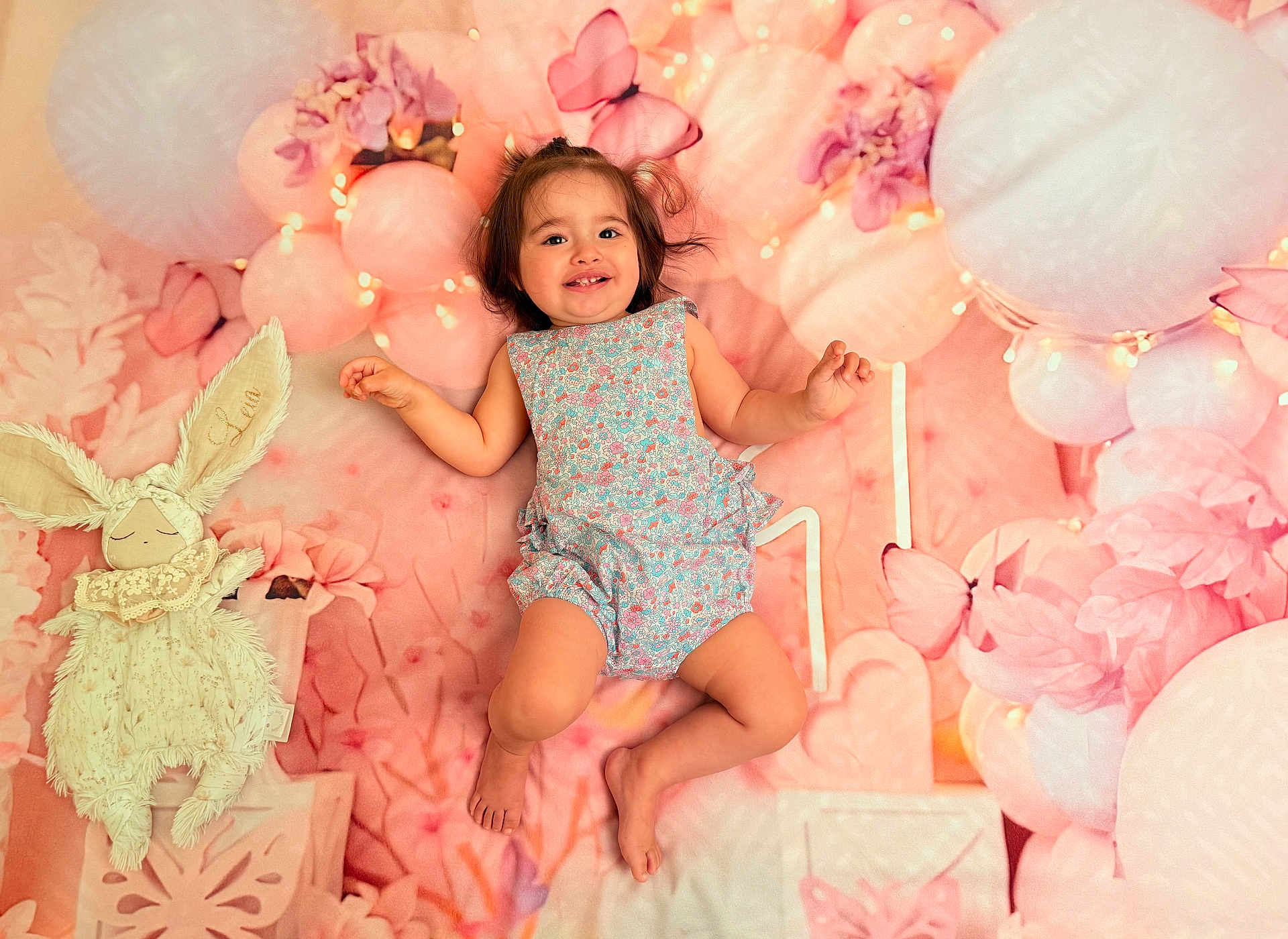 Leia a rejoint le concours — aidez-le/la à gagner de superbes lots ! baby, child, smiling, plush_toy, bunny, pink, balloon, flower, butterfly, background, cute, happy, infant, soft_toy, portrait, one_person, indoors, clothing, dress, lying_down