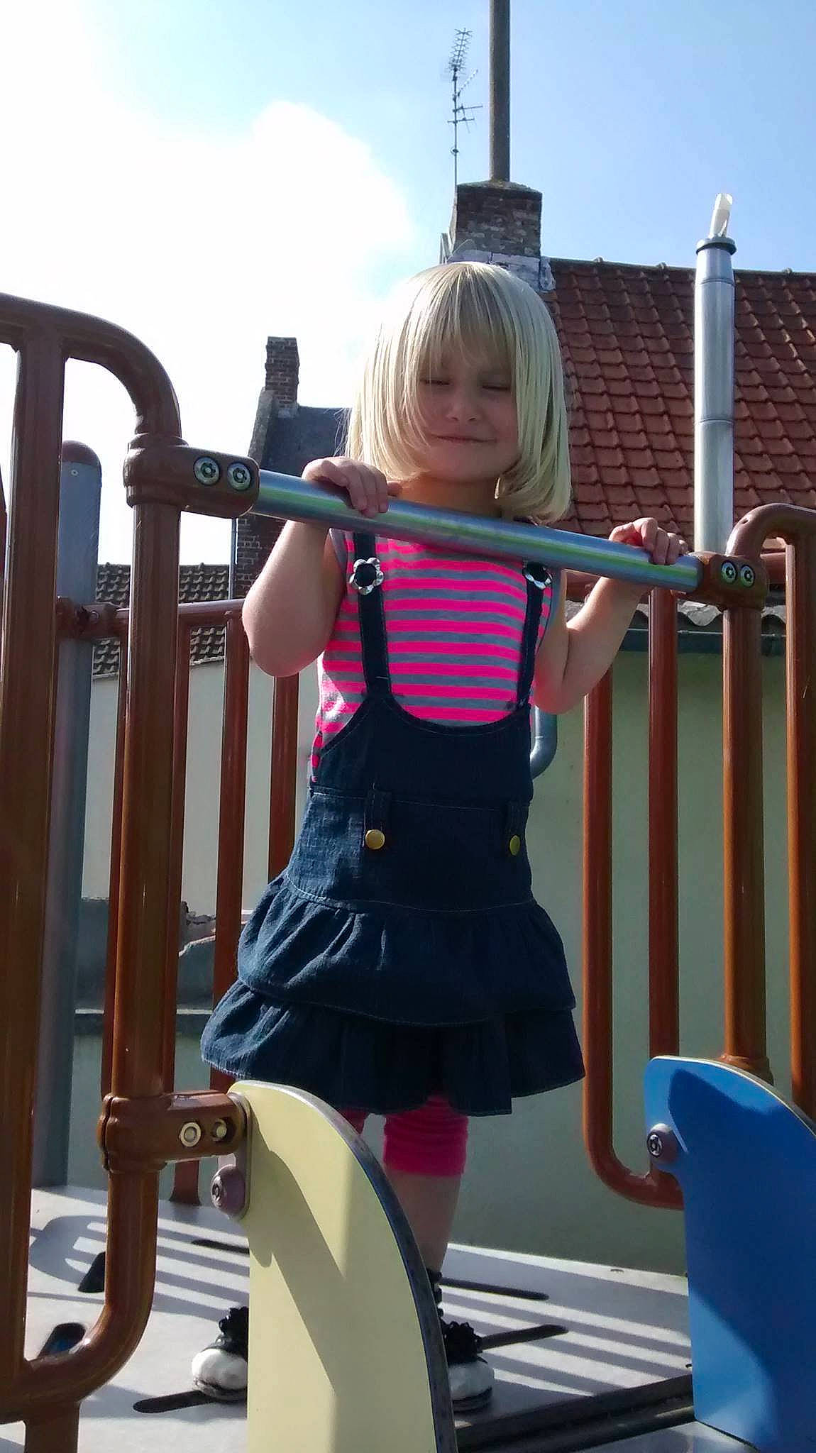 Laila participe au concours pour gagner de l'argent avec cette photo : blond, child, city, human_settlement, leg, outdoor_play_equipment, person, play, playground, public_space, recreation, shoulder, toddler, vacation