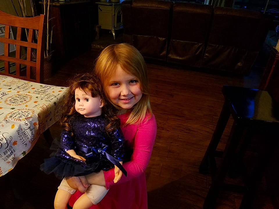 Melanie joined the competition — help win amazing prizes! chair, child, event, facial_expression, floor, flooring, fun, furniture, hairstyle, happy, iris, joy, lap, leisure, person, purple, sitting, smile, standing, table