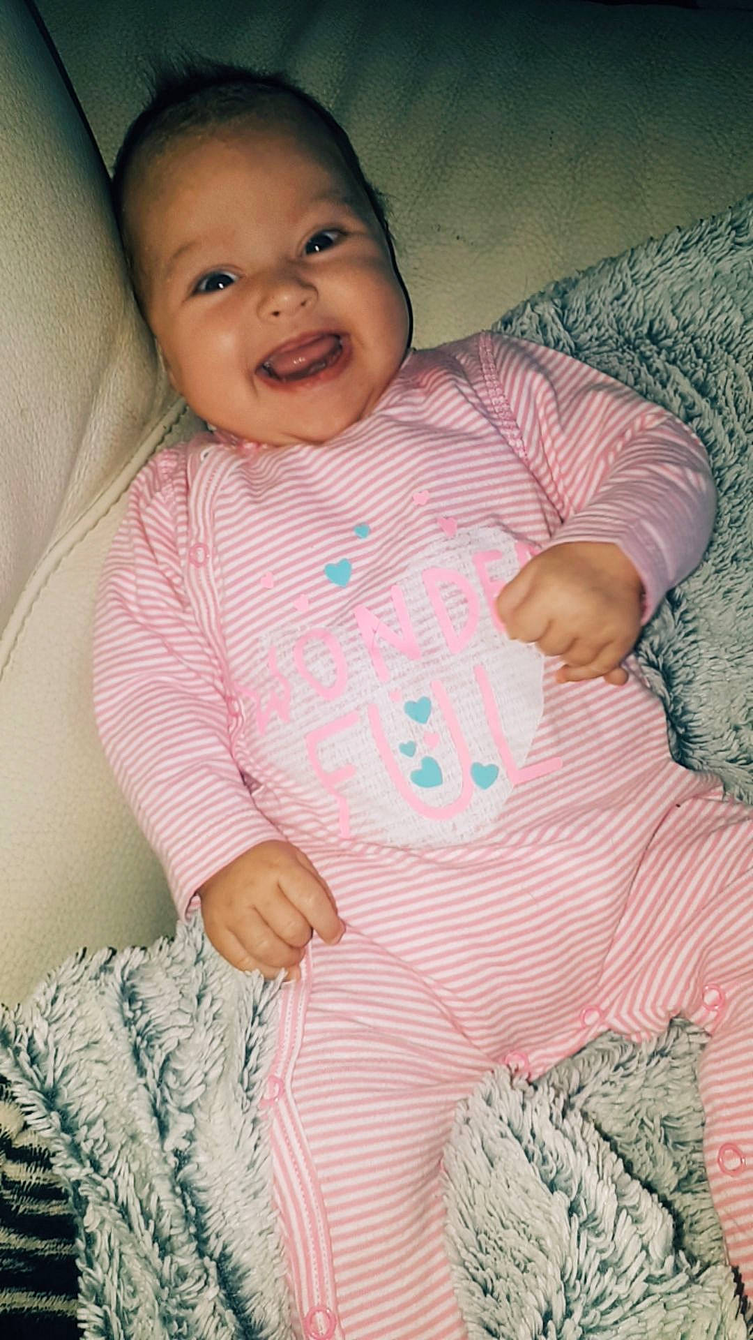 Eva participe au concours pour gagner de l'argent avec cette photo : baby, baby_products, baby_toddler_clothing, beauty, cheek, child, daughter, eye, face, facial_expression, head, lip, nose, person, pink, sitting, skin, sleeve, smile, toddler