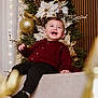 black_pants, celebration, child, christmas_tree, decorations, festive, golden_balls, happy, holiday, holiday_decor, indoors, joyful, lights, poinsettia, portrait, seasonal, smiling, sneakers, sweater, toddler