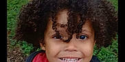 Jewlz is registered to the contest to win money with this photo: child, smiling, curly_hair, outdoor, grass, fence, happy, face, person, red_shirt, jacket, portrait, nature, young, cute, joyful, expression, kid, casual_clothing, daytime