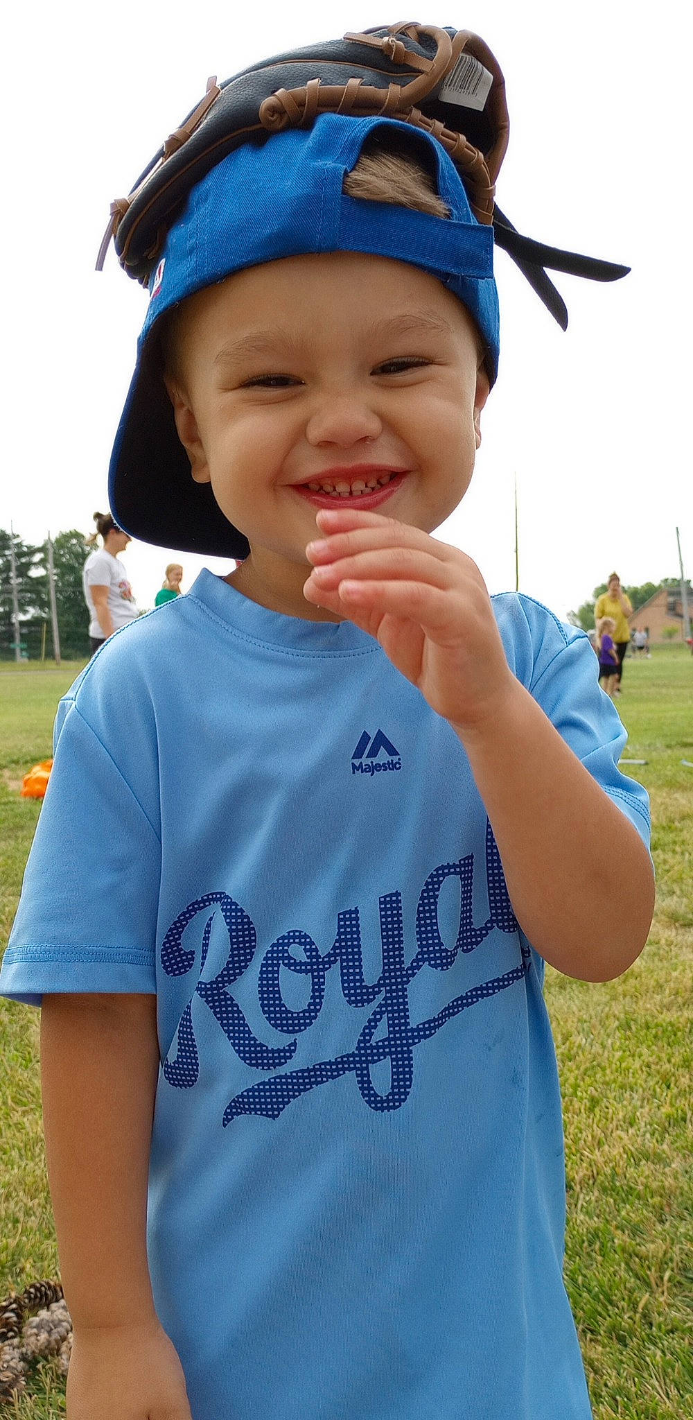 Brax is registered to the contest to win money with this photo: baseball_cap, blue, cap, clothing, cool, electric_blue, finger, gesture, grass, happy, headgear, headwear, joy, leisure, person, recreation, sky, sleeve, smile, summer