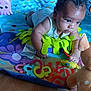 baby, infant, play_mat, toys, plush_toy, floor, indoor, child, curious, colorful, soft_toys, crawling, person, baby_toys, wooden_floor, cute, closeup, baby_girl, baby_boy, playtime