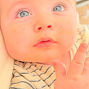 Imran participe au concours pour gagner de l'argent avec cette photo : baby, infant, blue_eyes, close_up, face, hand, striped_clothing, soft_lighting, cute, child, portrait, skin, young, looking_up, expression, person, indoors, newborn, adorable, curious