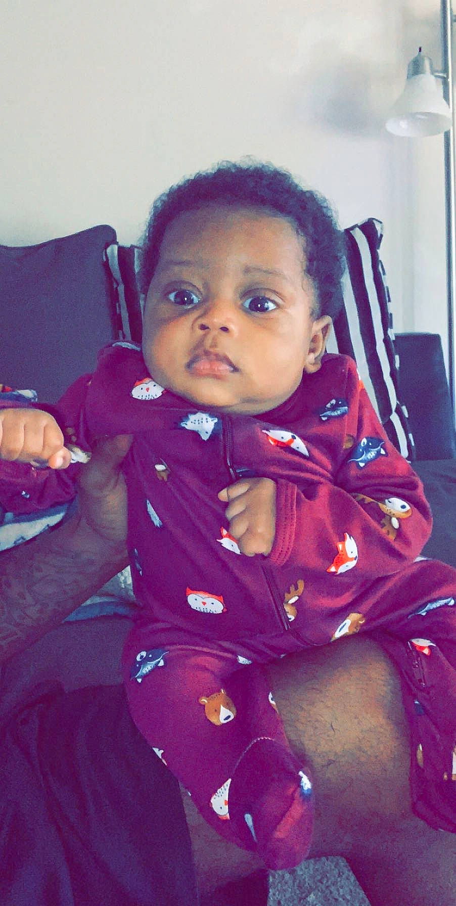 Javon is registered to the contest to win money with this photo: baby, cheek, child, eye, face, forehead, head, lip, outerwear, person, pink, purple, sitting, skin, smile, toddler