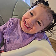 London joined the competition — help win amazing prizes! toddler, child, smile, high_chair, purple_sweater, pigtails, happy, indoor, face, person, cute, young_child, hair_bow, portrait, baby, ruffles, clothing, window, home, cheerful