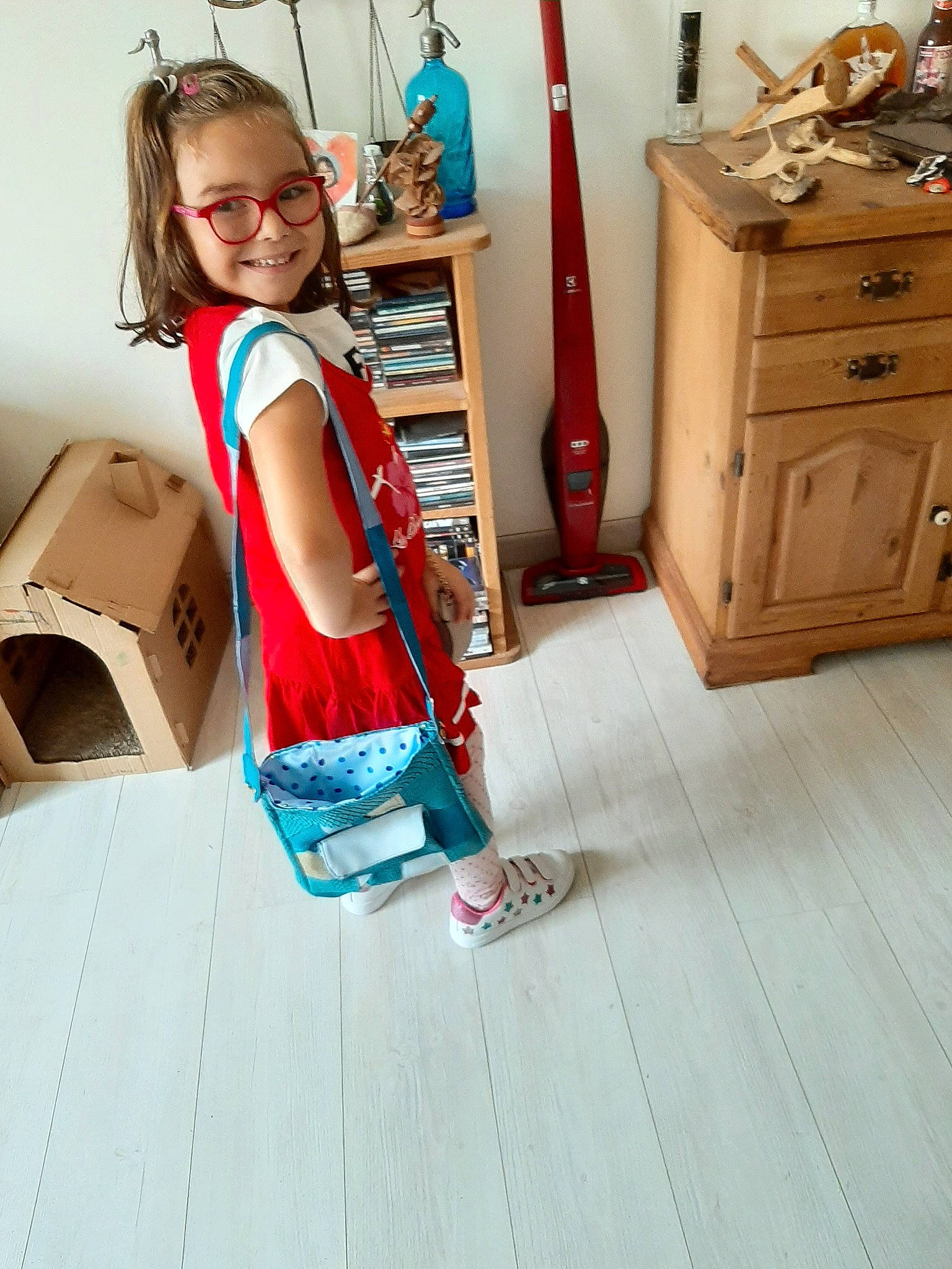 Ciara participe au concours pour gagner de l'argent avec cette photo : child, child_model, diaper_bag, dress, floor, flooring, footwear, furniture, hardwood, joy, laminate_flooring, person, play, room, shoe, shoulder, standing, toddler, turquoise, waist