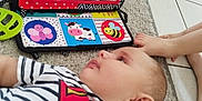 Lissandro participe au concours pour gagner de l'argent avec cette photo : animal_illustration, baby, carpet, child, colorful, cute, floor, foot, hand, indoor, mirror, person, playtime, reflection, reflection_in_mirror, smiling, striped_clothing, superman_shirt, tile_floor, toy