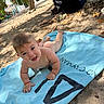 baby, towel, beach, sand, smiling, child, outdoor, sunlight, happy, barefoot, summer, nature, playful, person, daytime, trees, vacation, relaxation, skin, expression
