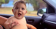 Dariel Frontela is registered to the contest to win money with this photo: adult, baby, blue_towel, bracelet, car_interior, child, diaper, expression, hand, happy, nature, outdoor, person, portrait, seat, skin, smiling, supporting_hand, tattoo, window