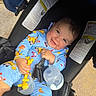 Dariel Frontela is registered to the contest to win money with this photo: baby, child, smile, stroller, blue_outfit, toy, bottle, sunlight, happy, infant, playful, cartoon_print, sitting, face, hand, outdoor, cute, young_child, casual, comfort