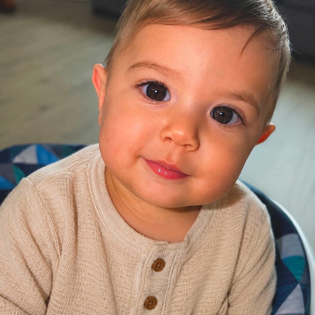 Dariel Frontela is registered to the contest to win money with this photo: baby, child, portrait, face, smile, eyes, knit_sweater, beige, indoor, seat, patterned, curious, cute, infant, young_child, happy, cozy, closeup, home, soft_lighting