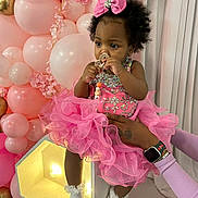 Beautiful is registered to the contest to win money with this photo: baby, child, pink_dress, tutu, bow, curly_hair, pacifier, hand, watch, bracelet, balloons, pink_balloons, gold_balloons, party, celebration, curtains, cute, adorable, infant, indoor