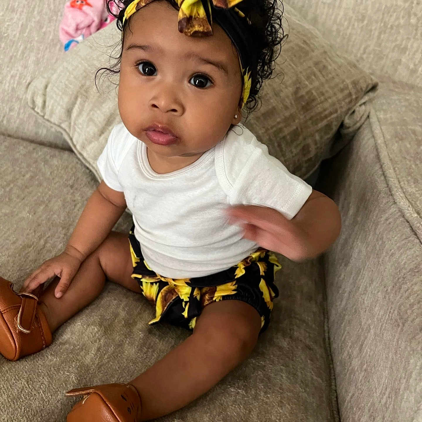 Alaia is registered to the contest to win money with this photo: accessories, baby, blackhair, clothing, couch, cushion, face, furniture, hair, head, headband, homedecor, pants, people, person, photography, portrait, shorts, sitting, sleeve