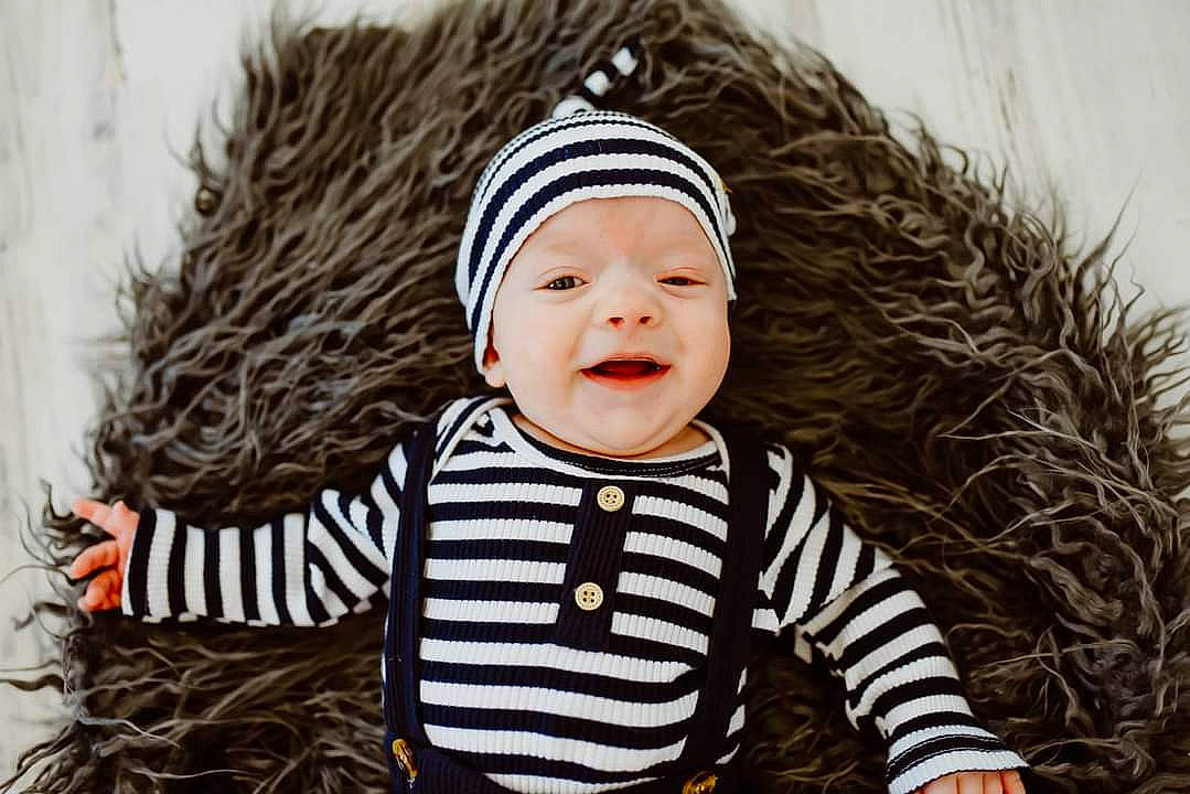 Leonidas is registered to the contest to win money with this photo: baby, baby_toddler_clothing, cap, child, eye, fun, grass, happy, headgear, headwear, knit_cap, outerwear, pattern, people_in_nature, person, skin, sleeve, smile, toddler, tree