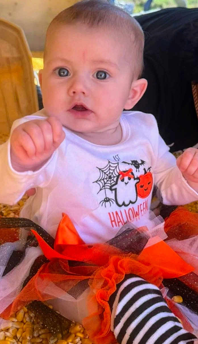 Madilynn is registered to the contest to win money with this photo: baby, child, halloween, costume, ghost, pumpkin, tulle, corn, striped_socks, cute, infant, portrait, clothing, celebration, festive, indoors, person, expression, hand, sitting