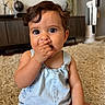 baby, child, infant, romper, blue_clothing, curly_hair, sitting, indoor, carpet, rug, hand_on_face, cute, adorable, portrait, young_child, home_interior, lamp, furniture, expression, face