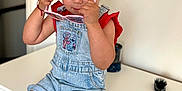 Evelyn is registered to the contest to win money with this photo: toddler, child, girl, sunglasses, pigtails, denim_overalls, red_shirt, dresser, hairbrush, wall_stickers, teddy_bear, stars, indoor, furniture, curious, blue_eyes, skin, casual_clothing, cute, portrait