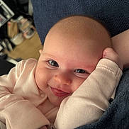 Ava is registered to the contest to win money with this photo: baby, smiling, tongue_out, close_up, infant, cute, person, indoor, cushion, clothing, face, head, skin, hand, expression, happy, newborn, cozy, texture, portrait