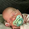baby, sleeping, pacifier, infant, pink_pajamas, hand, face, resting, closeup, skin, head, peaceful, cute, newborn, indoors, blanket, comfort, soft, young_child, nap