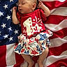 baby, infant, sleeping, american_flag, red_shirt, star_pattern, skirt, clothing, cute, peaceful, patriotic, fabric, stars, stripes, person, portrait, newborn, resting, soft, celebration