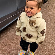 Angelo participe au concours pour gagner de l'argent avec cette photo : toddler, child, smiling, jacket, teddy_bear_pattern, footwear, slippers, cartoon_character, outdoor, pavement, car, vehicle, standing, happy, cute, portrait, clothing, warm_clothes, young_child, person