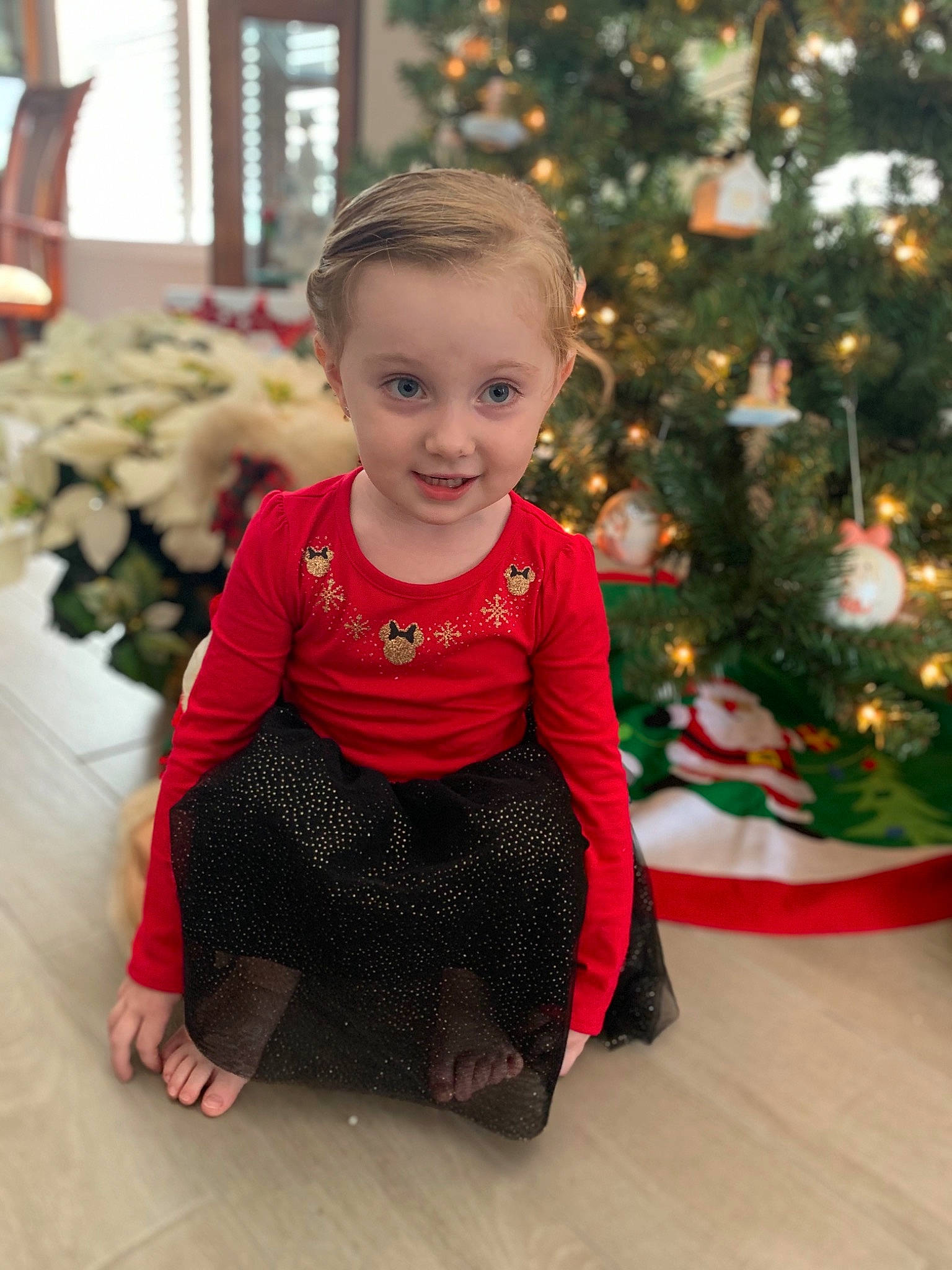Alyson is registered to the contest to win money with this photo: baby, child, christmas, christmas_decoration, christmas_eve, christmas_ornament, christmas_tree, event, face, facial_expression, happy, head, holiday, joy, outerwear, person, red, sitting, smile, standing