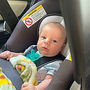 Oliver joined the competition — help win amazing prizes! baby, car_seat, blanket, pacifier, infant, child, seatbelt, safety, warning_label, clothing, hand, face, head, blue_eyes, indoor, transportation, car, cute, newborn, portrait