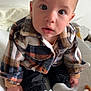 baby, bed, blanket, child, clothing, cozy, curious, cute, expression, face, feet, hands, indoors, infant, plaid_jacket, portrait, sitting, soft_toy, warm, white_socks