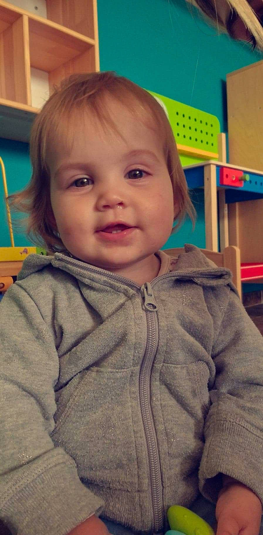 Aryanna a rejoint le concours — aidez-le/la à gagner de superbes lots ! baby, baby_toddler_clothing, blue, cheek, child, chin, flooring, fun, happy, iris, nose, person, room, sitting, skin, sleeve, smile, toddler, wood, wool