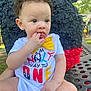 Delani joined the competition — help win amazing prizes! toddler, child, baby, onesie, yellow_bow_tie, sitting, fingers_in_mouth, outdoor, bench, piñata, curly_hair, earrings, park, greenery, people, daylight, cute, portrait, playful, festive