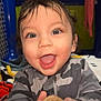 toddler, child, smiling, blue_eyes, wet_hair, toy, cookie_toy, camo_jacket, indoor, play_area, happy, close_up, portrait, cute, baby, hands, expression, face, person, young_child