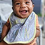 Marshall is registered to the contest to win money with this photo: baby, smiling, bib, child, happy, person, infant, cute, holding, closeup, portrait, orange_clothing, new_cousin, face, skin, mouth_open, eyes, arms, legs, indoors