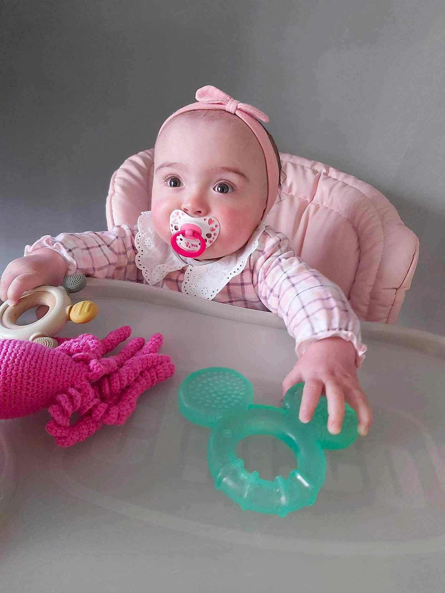 Kayna a rejoint le concours — aidez-le/la à gagner de superbes lots ! baby, baby_playing_with_toys, baby_products, baby_safety, baby_toddler_clothing, chair, cheek, child, comfort, dress, eye, human_body, person, pink, product, sitting, skin, sleeve, textile, toddler