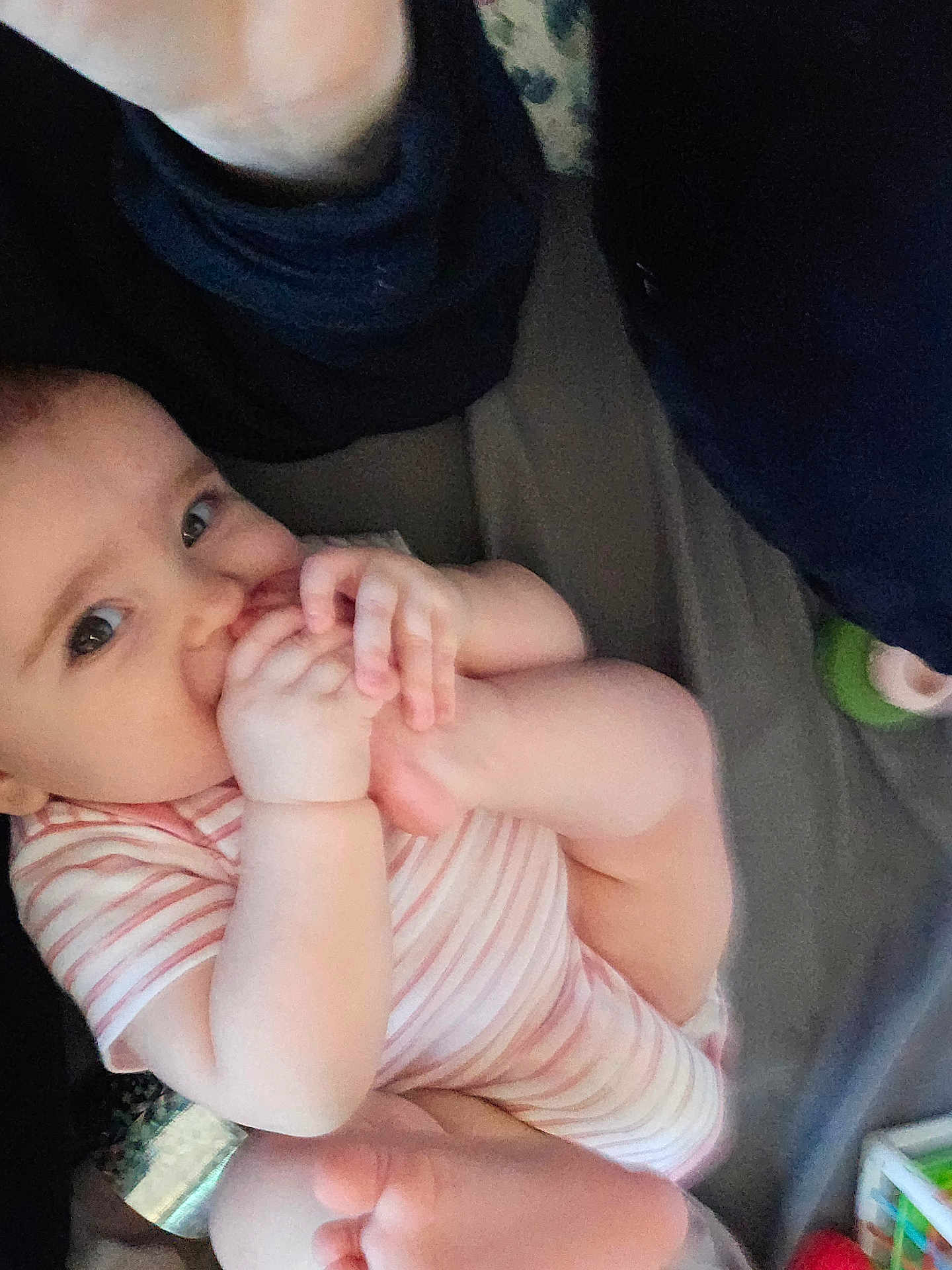 Daevii Lee is registered to the contest to win money with this photo: baby, infant, foot, hand, onesie, striped_clothing, cute, child, mouthing, skin, person, looking, indoors, soft_lighting, candid, exploration, flexibility, young_child, adorable, closeup