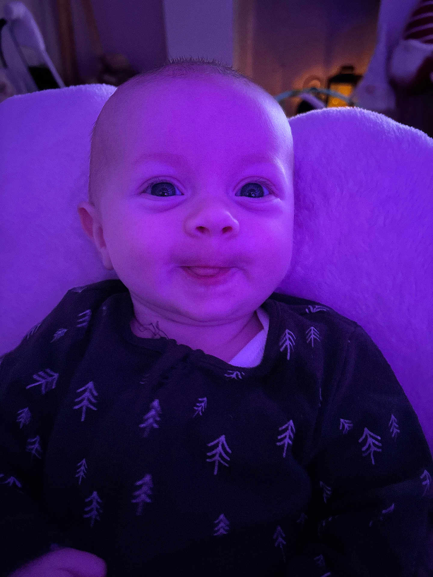 Rue joined the competition — help win amazing prizes! baby, infant, face, tongue, purple_light, clothing, pattern, tree_pattern, cushion, soft_texture, indoor, portrait, smiling, happy, child, young, cute, cozy, closeup, person