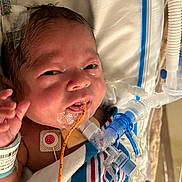 Kaizlyn joined the competition — help win amazing prizes! newborn, baby, hospital, medical_tubes, blanket, face, infant, monitor, hospital_wristband, bed, healthcare, patient, medical_equipment, cute, person, child, lying_down, indoors, closeup, vital_signs