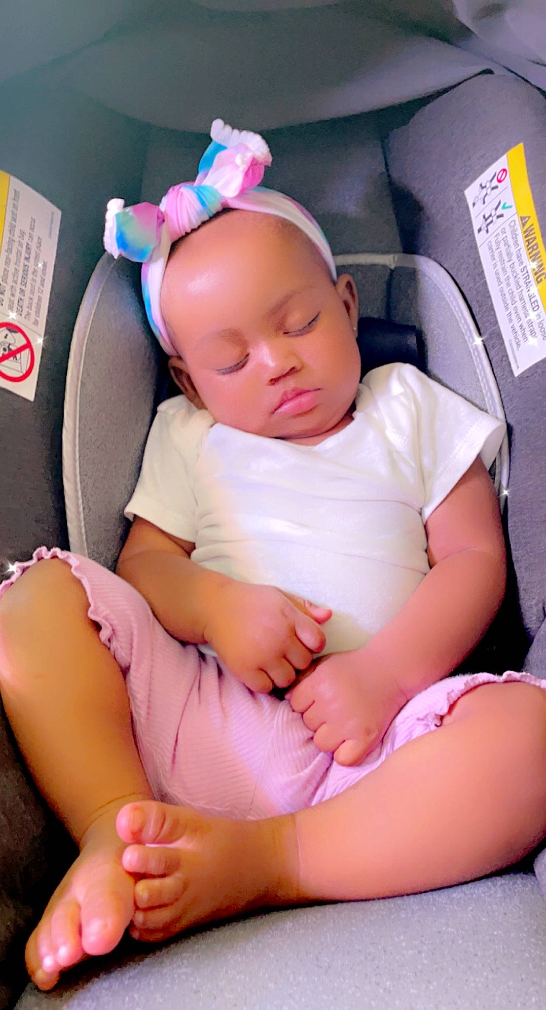 Uri is registered to the contest to win money with this photo: auto_part, baby, baby_in_car_seat, baby_products, baby_toddler_clothing, blond, car_seat, cheek, child, comfort, eyelash, finger, human_leg, knee, nail, person, pink, sitting, skin, thigh