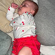 Janiyah joined the competition — help win amazing prizes! baby, infant, sleeping, pillow, blanket, onesie, cherry_print, red_shorts, legs, feet, ear, cheek, bedding, soft_texture, nap, cozy, indoors, portrait, peaceful, cute