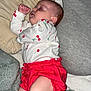 baby, infant, sleeping, pillow, blanket, onesie, cherry_print, red_shorts, legs, feet, ear, cheek, bedding, soft_texture, nap, cozy, indoors, portrait, peaceful, cute