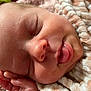 baby, infant, newborn, sleeping_face, close_up, face, nose, lips, tongue, eyelashes, hand, blanket, swaddle, skin, cozy, soft_texture, portrait, macro, peaceful, cherubic