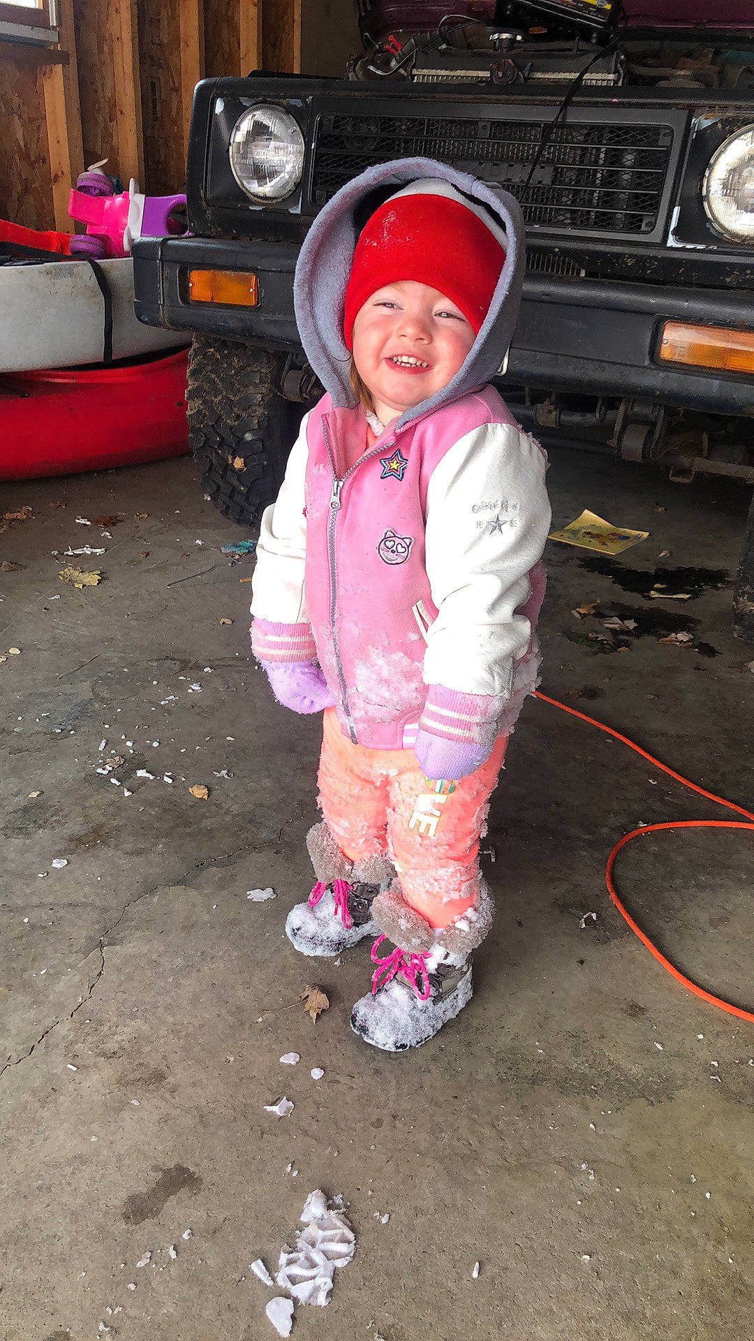 Harper is registered to the contest to win money with this photo: automotive_design, automotive_exterior, automotive_lighting, automotive_tire, bumper, car, fender, hat, headgear, headwear, helmet, hood, joy, motor_vehicle, person, pink, shoe, smile, sneakers, tire