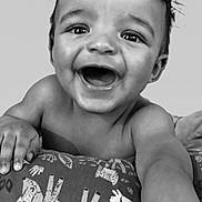 Kai Eli is registered to the contest to win money with this photo: baby, child, smile, happy, face, hand, arm, cushion, pattern, animal_print, black_and_white, portrait, cute, infant, expression, closeup, skin, eyes, mouth, indoor
